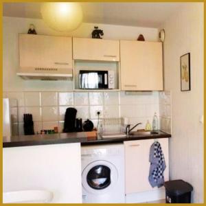 una cocina con lavadora y microondas en Le Lodge Central - Parking - Vue Piscine - By Montauban City, en Montauban