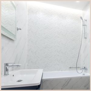Baño blanco con lavabo y bañera en Le Lodge Central - Parking - Vue Piscine - By Montauban City, en Montauban