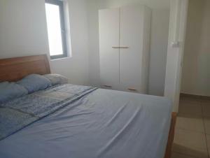 a bedroom with a large bed with a window at Petite Villa duplex à Green Village in Goodlands