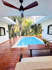 a swimming pool with a ceiling fan and a bench at Cosmos House in the Jungle in Santa Teresa Beach