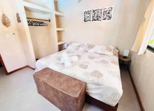 a small bedroom with a bed and a stool at Cosmos House in the Jungle in Santa Teresa Beach