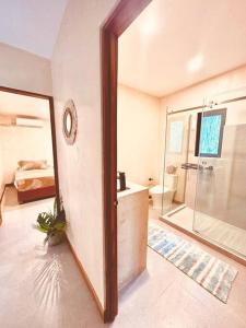 a bathroom with a tub and a shower and a mirror at Cosmos House in the Jungle in Santa Teresa Beach