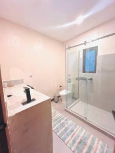 a bathroom with a glass shower and a sink at Cosmos House in the Jungle in Santa Teresa Beach