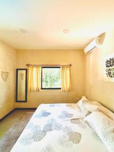 a bedroom with a bed and a window at Cosmos House in the Jungle in Santa Teresa Beach