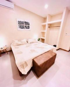 a bedroom with a large bed with a brown ottoman at Cosmos House in the Jungle in Santa Teresa Beach