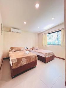 a bedroom with two beds and a window at Cosmos House in the Jungle in Santa Teresa Beach