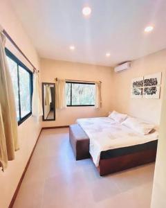 a bedroom with a large bed and two windows at Cosmos House in the Jungle in Santa Teresa Beach