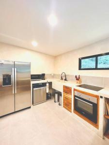 a kitchen with stainless steel appliances and a window at Cosmos House in the Jungle in Santa Teresa Beach