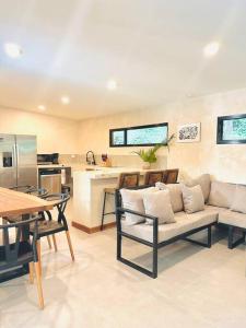 a living room with a couch and a kitchen at Cosmos House in the Jungle in Santa Teresa Beach