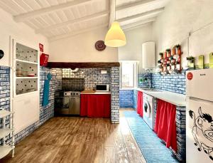 a kitchen with red counters and a brick wall at Hakuna Matata in Cano