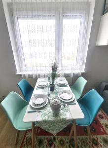 a dining room table with blue chairs and a window at RentinAustria in Reisenberg