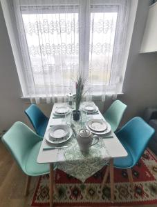 a dining room table with blue chairs and a window at RentinAustria in Reisenberg