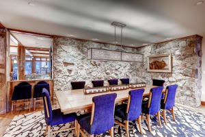 a dining room with a wooden table and blue chairs at Bachelor Gulch Village by Vail Resorts in Avon +291 photos