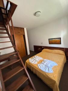 Un dormitorio con una cama y una escalera. en Hostería Santa Bárbara, en Villa Gesell