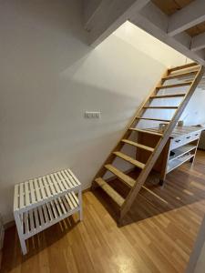 a loft room with a wooden staircase and a bench at La Tomate Surfeuse 2 in Hourtin