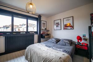 a bedroom with a bed and a large window at Maison avec terrasse parfaite pour les 24H et GP Moto in Le Mans