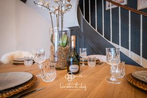 a bottle of wine sitting on a table with glasses at Maison avec terrasse parfaite pour les 24H et GP Moto in Le Mans