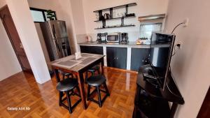 a small kitchen with a table and stools and a refrigerator at Galápagos Volcanic II in Puerto Ayora