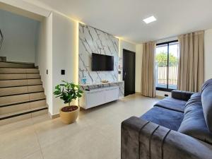 een woonkamer met een bank en een tv bij Sobrado novíssimo 3 quartos melhor bairro de foz in Foz do Iguaçu