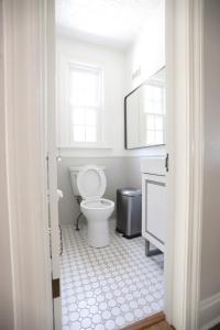 a white bathroom with a toilet and a mirror at Purdue Bell Tower views, Central WL location, Walk 2 Purdue in West Lafayette +44 photos