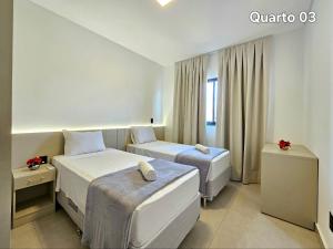 een hotelkamer met twee bedden en een raam bij Sobrado novíssimo 3 quartos melhor bairro de foz in Foz do Iguaçu