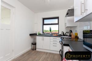 una cucina bianca con lavandino e finestra di Spacious 3 bed, 2 min from A1, Durham a Durham Altre 8 foto