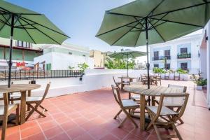 a patio with tables and chairs with umbrellas at Casa Las Ruinas by Stay with Bear in San Juan