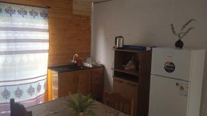 a kitchen with a white refrigerator and a table with a table at Casa céntrica cómoda in Chuí +1 photo