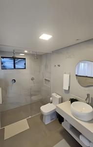 a bathroom with a toilet and a sink and a shower at Recanto Pôr do Sol com banheira e lareira in Santo Amaro da Imperatriz +60 photos