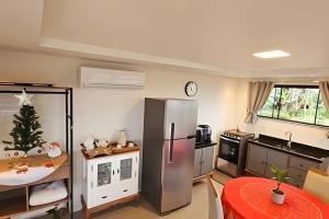 a kitchen with a stainless steel refrigerator and a christmas tree at Recanto Pôr do Sol com Hido e lareira in Santo Amaro da Imperatriz