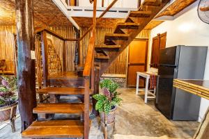 a wooden staircase in a kitchen with a refrigerator at 3 BR Native House at Port Barton Center in San Vicente