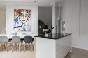 a kitchen and dining room with a painting on the wall at Glorious penthouse with private sauna and jacuzzi in Helsinki