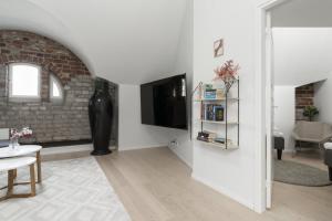 a white living room with a television and a table at Glorious penthouse with private sauna and jacuzzi in Helsinki