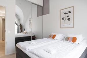 a bedroom with a large bed with white sheets at Glorious penthouse with private sauna and jacuzzi in Helsinki