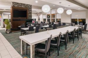 a conference room with tables and chairs and a flat screen tv at Residence Inn by Marriott Harrisonburg in Harrisonburg