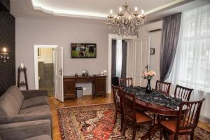 Una sala de estar con una mesa de comedor y un sofá. en Weidner Apartments, en Sibiu