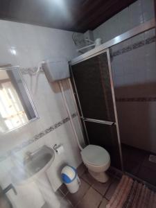 a small bathroom with a toilet and a sink at Apartamento Duplex na praia de Salinas RS in Cidreira +15 photos