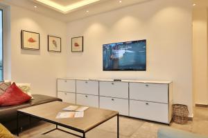 ein Wohnzimmer mit einem Fernseher an der Wand in der Unterkunft Haus Wolburgstraße 1 Haus Wolburgstraße 1a Penthouse Haifisch Appartement 5 in Timmendorfer Strand