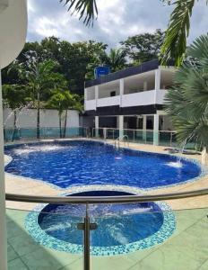 a large swimming pool in front of a building at Parcela de Alquiler VILLA CAMI in Piedecuesta