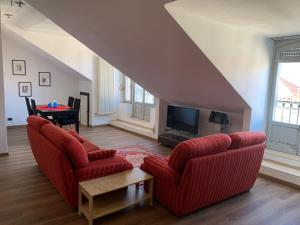 sala de estar con 2 sillas rojas y TV en Casa LEA, en Luino