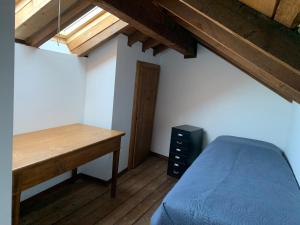 Habitación con cama y escritorio de madera. en Casa LEA, en Luino