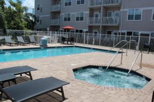 a pool in front of a building with a table and a bench at Residence Inn by Marriott Sebring in Sebring