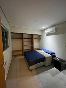 a bedroom with a bed and shelves in it at Casa Aconchegante próximo da balsa in Ilhabela