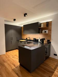 a kitchen with a black island in the middle at Chalet1500 Apartment Gerlitzen - Kärnten Card inklusive! in Kanzelhöhe +31 photos