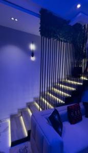 a living room with a couch and some stairs at BOTS Two Bedroom Duplex Apartment in Ilorin
