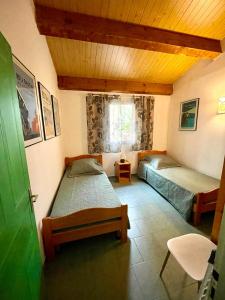 a bedroom with two beds and a green door at Le Râteau Bavoir in Calvi +25 photos