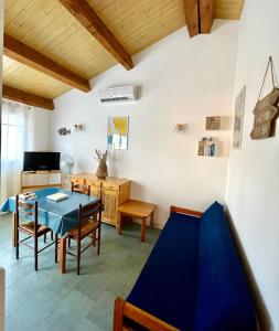 a dining room with a blue table and chairs at Le Râteau Bavoir in Calvi