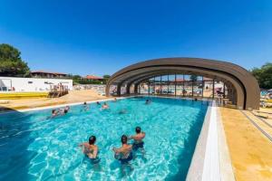a group of people in a swimming pool at Mobilhome La Plage in Mimizan-Plage