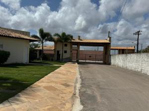 ein Haus mit einem Tor und einer Einfahrt in der Unterkunft Linda Casa Aconchegante Aquiraz in Aquiraz