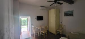 a room with a table and chairs and a window at Hotel Dory in Albinia